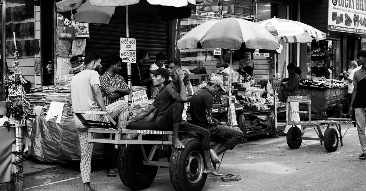 Black and white photo capturing a bustling street market scene in Colombo, Sri Lanka.