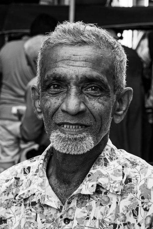 Free Black and white portrait of an elderly man smiling in a Colombo market, Sri Lanka. Stock Photo
