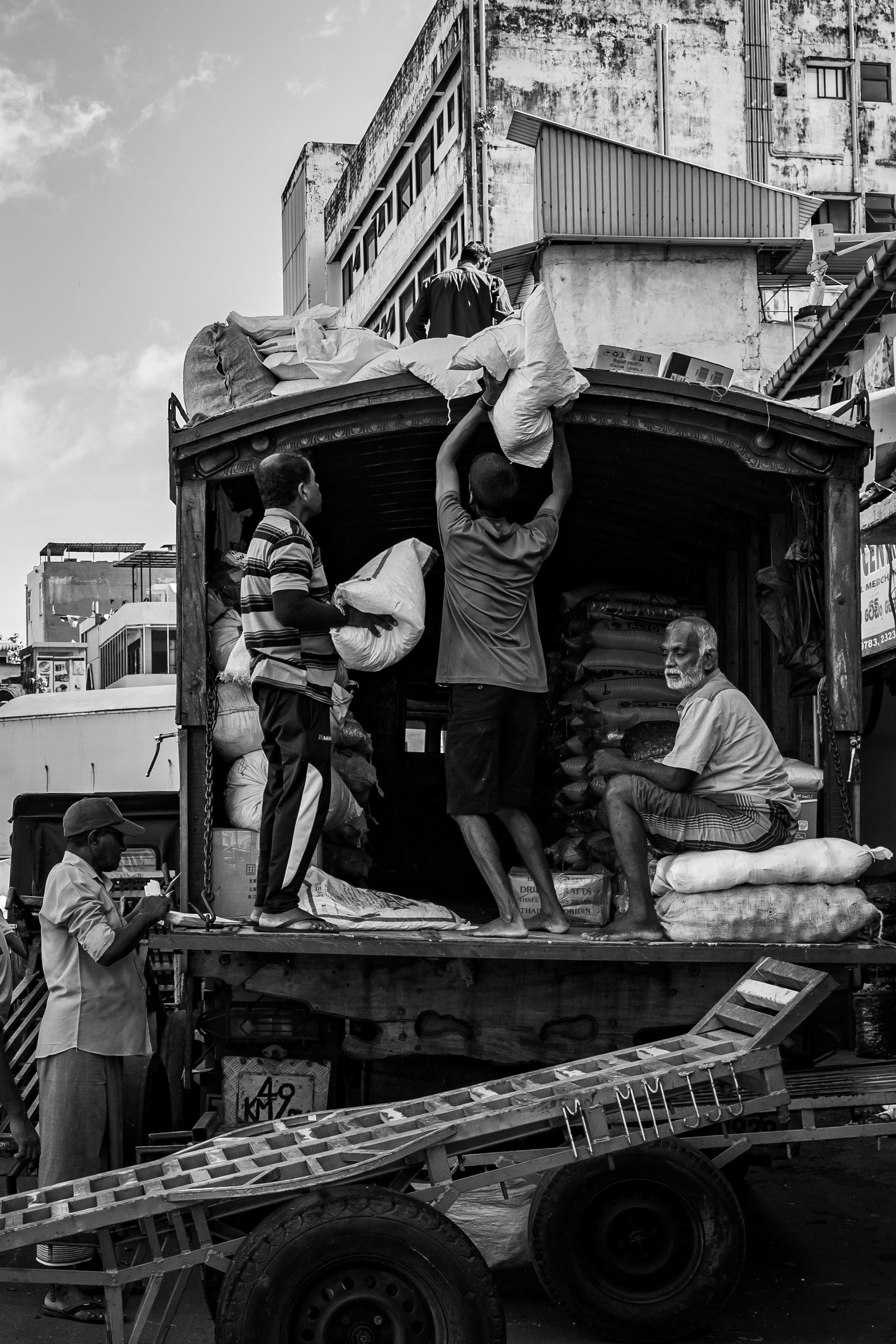 Workers loading goods onto a lorry on a Sri Lankan street