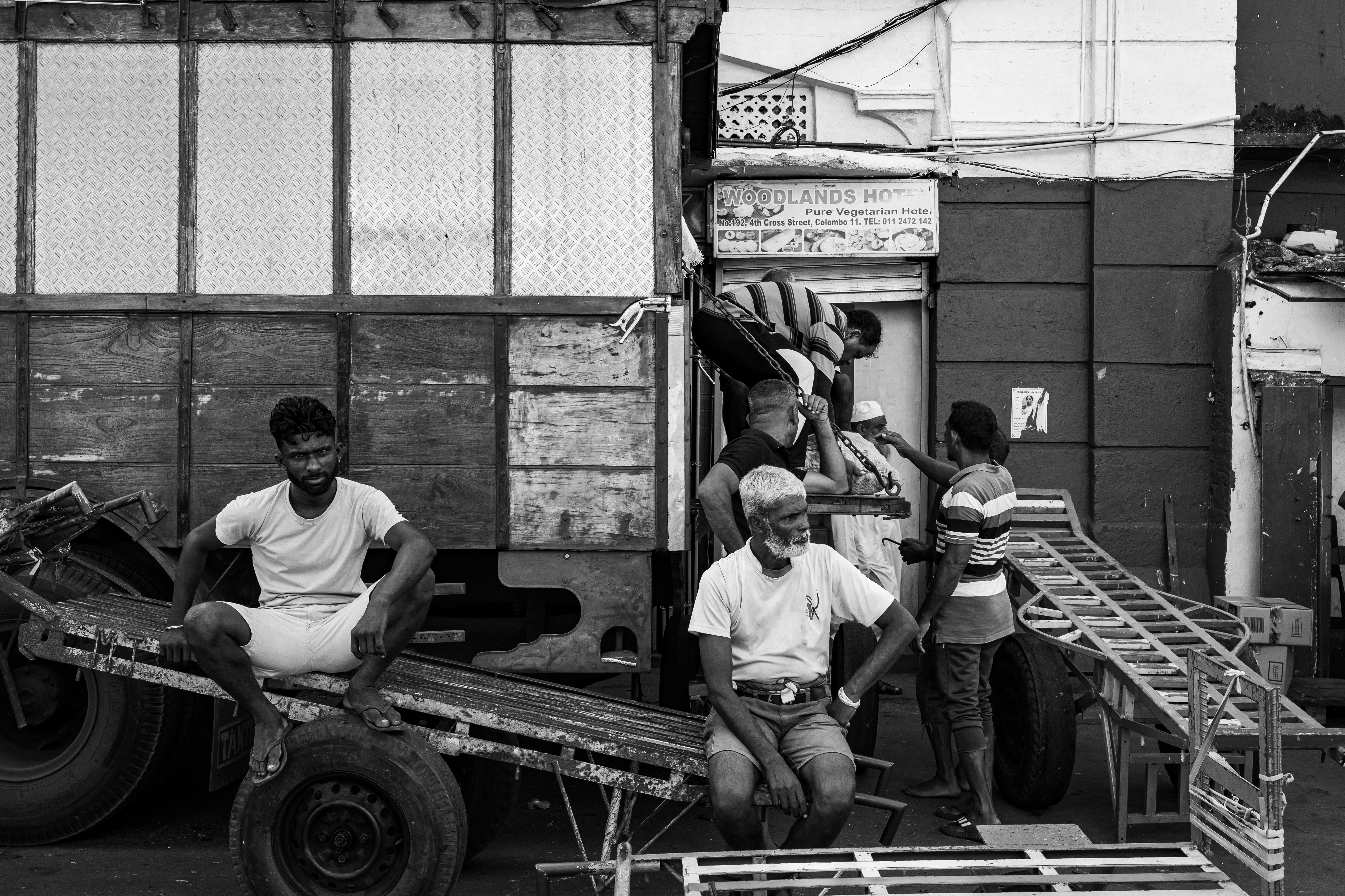 Family-owned roofing team standing beside a work truck loaded with ladders and shingle bundles outside a Fort Worth shop, morning light