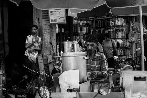 Free Busy street vendor serving drinks in a bustling Colombo market captured in black and white. Stock Photo