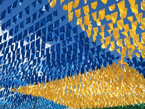 Colorful blue and yellow bunting flags flutter festively under a bright summer sky.