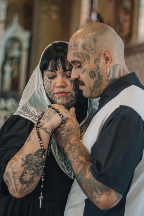 Free A tattooed couple shares an emotional moment in a church. Stock Photo