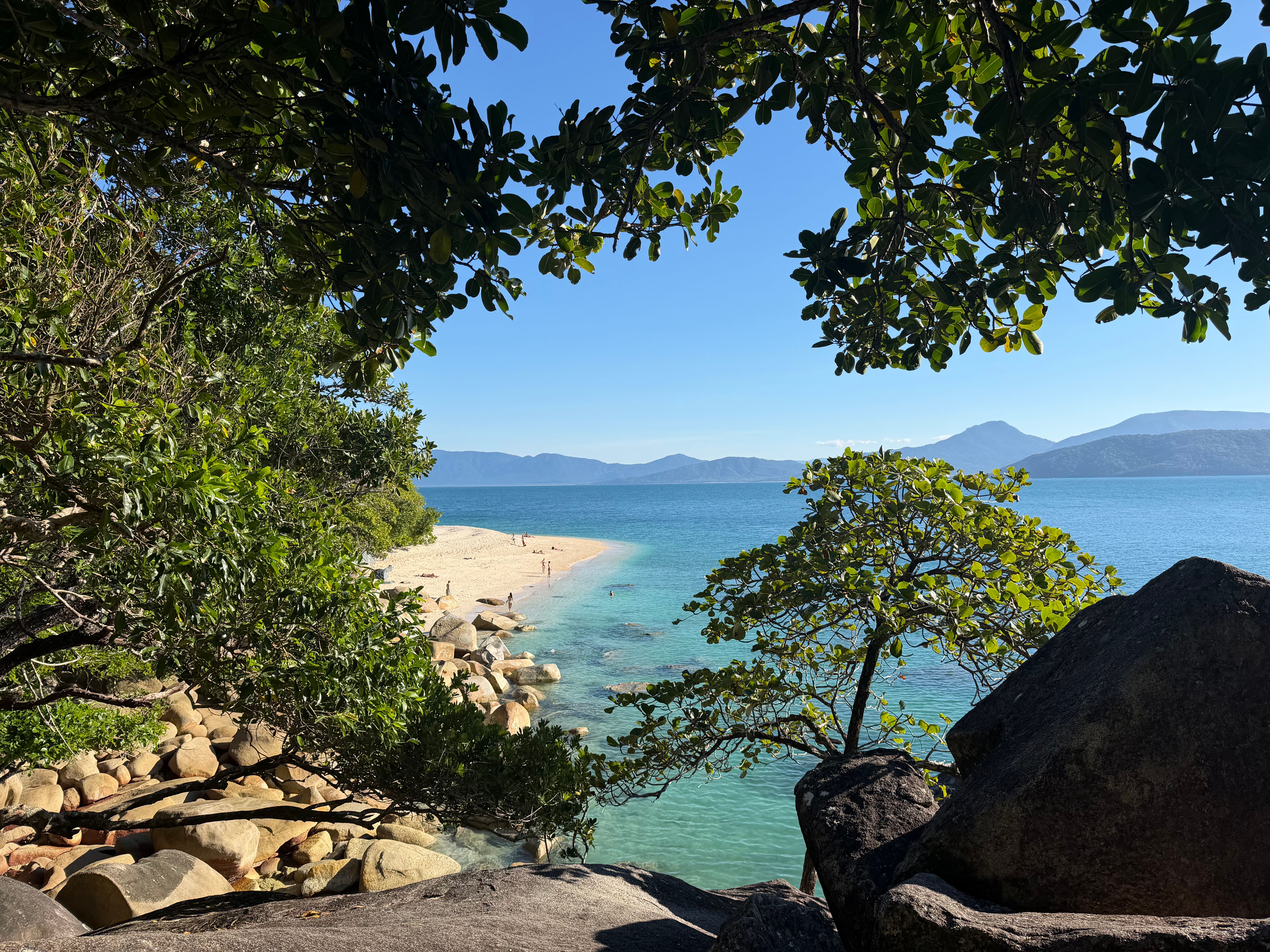 Serene tropical beach scene with turquoise waters and lush vegetation, perfect for a tranquil escape.