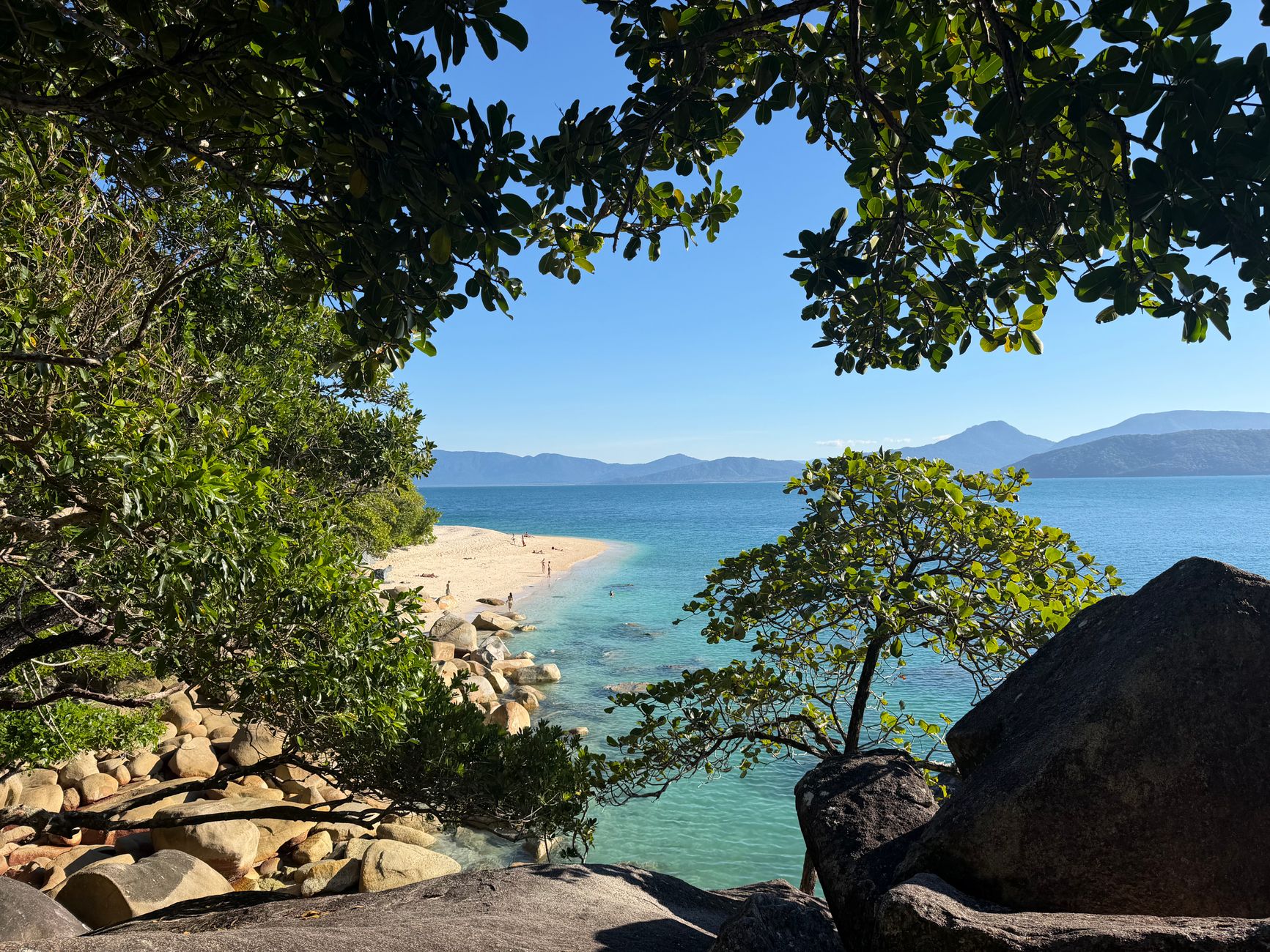 Serene tropical beach scene with turquoise waters and lush vegetation, perfect for a tranquil escape.