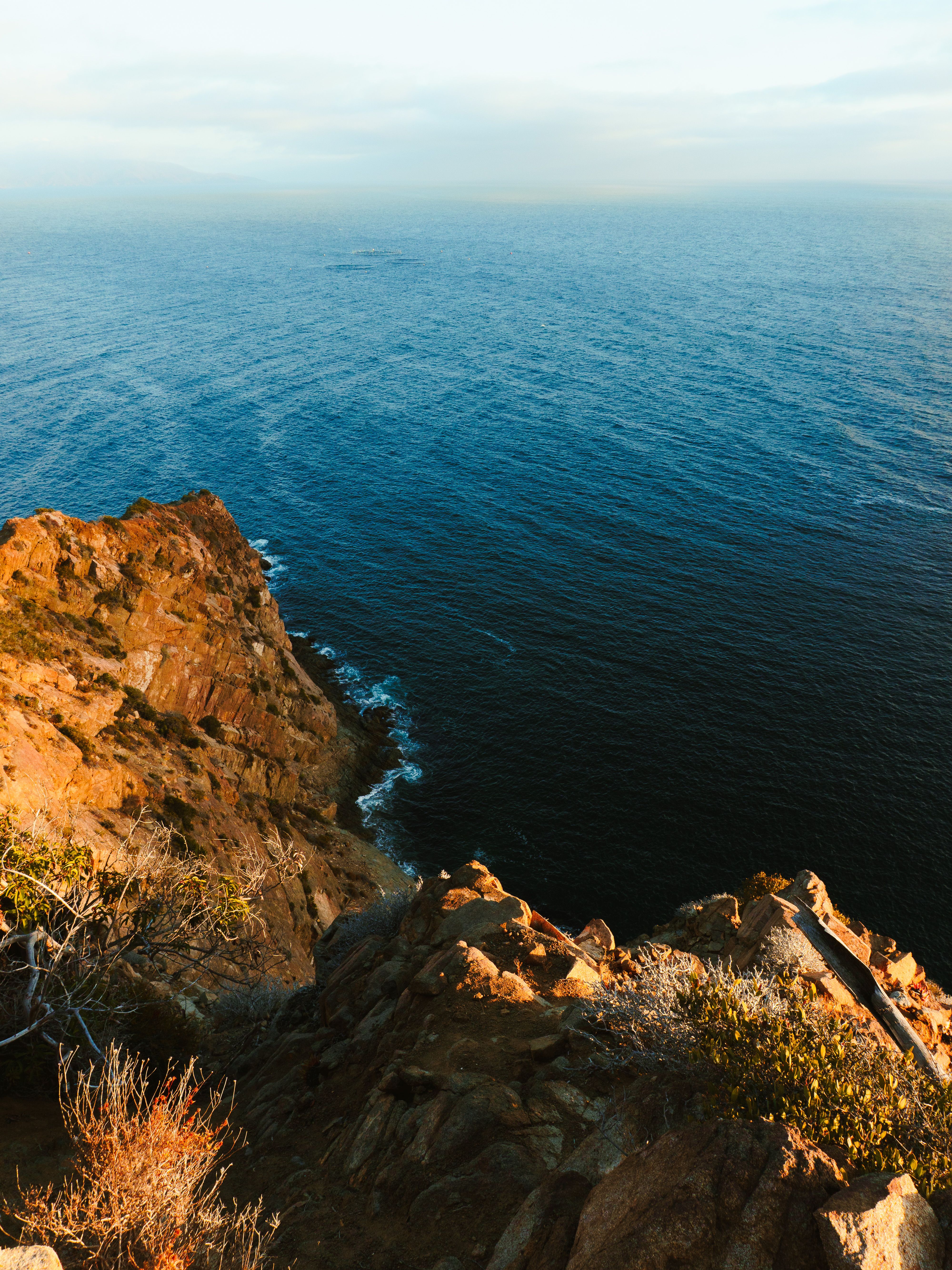 Captivating rocky cliffs overlooking the ocean at golden hour, perfect for nature lovers.