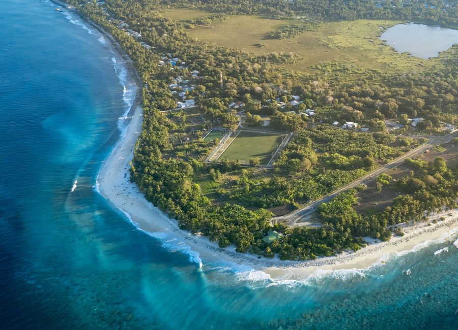 Stunning aerial view of a tropical island with lush greenery and turquoise waters.