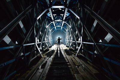 Silhouette of a person in a hat standing in a dark tunnel — Dikye Ariani on Pexels