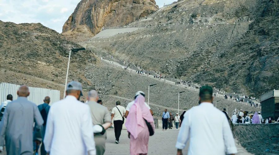 Pilgrims walking towards Jabal al-Nour, with the path to Cave Hira climbing the mountain behind them