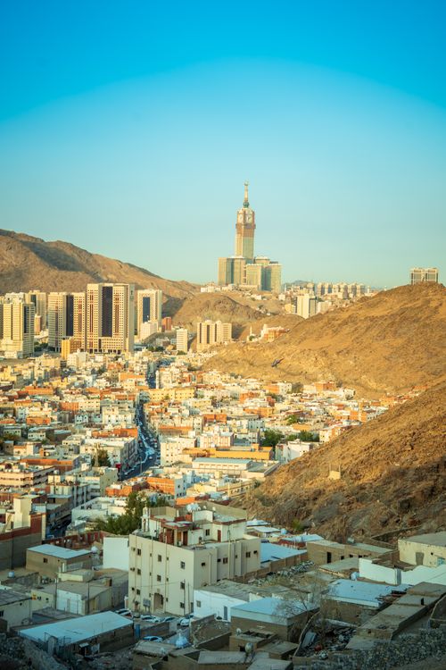 Free A breathtaking cityscape of Makkah featuring the iconic Abraj Al Bait towers against a mountainous backdrop. Stock Photo
