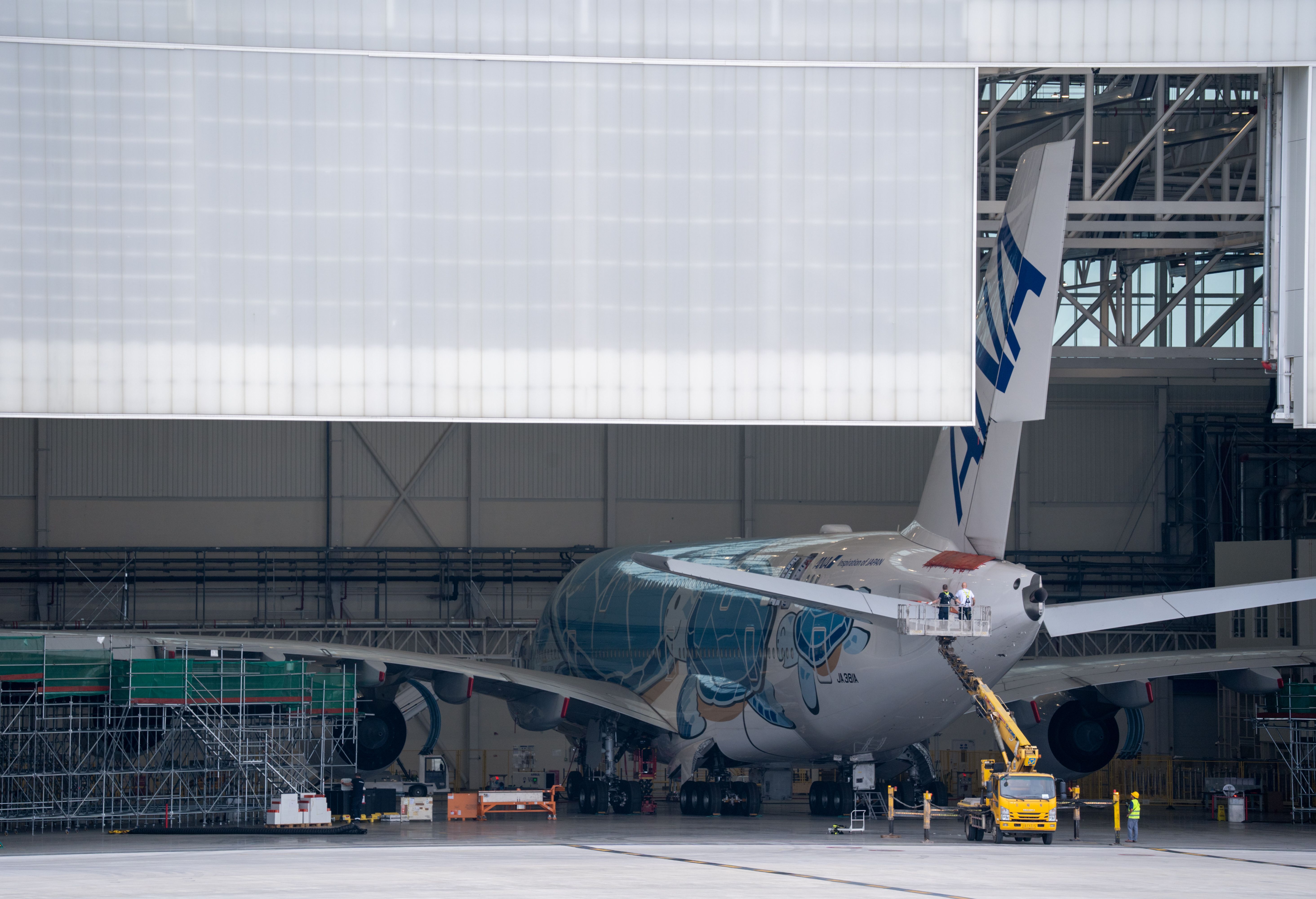 A large aircraft undergoing maintenance in a hangar, showcasing aviation industry operations.