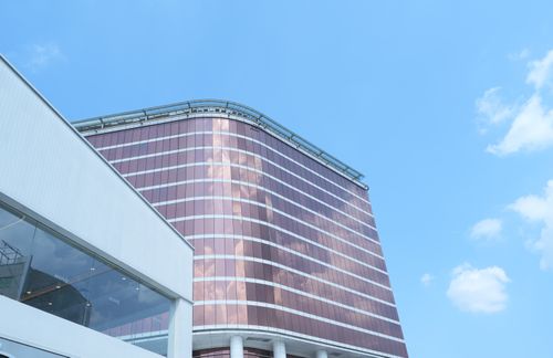 Free Sleek modern office building with glass facade reflecting the blue sky in Jawa Barat, Indonesia. Stock Photo