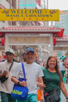 A joyful group strolls through Manila Chinatown, capturing the lively atmosphere.