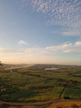 Beautiful sunrise over rolling green fields with a serene lake view. Perfect for nature lovers.