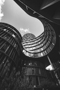A dramatic black and white photo of a modern spiral building from below.