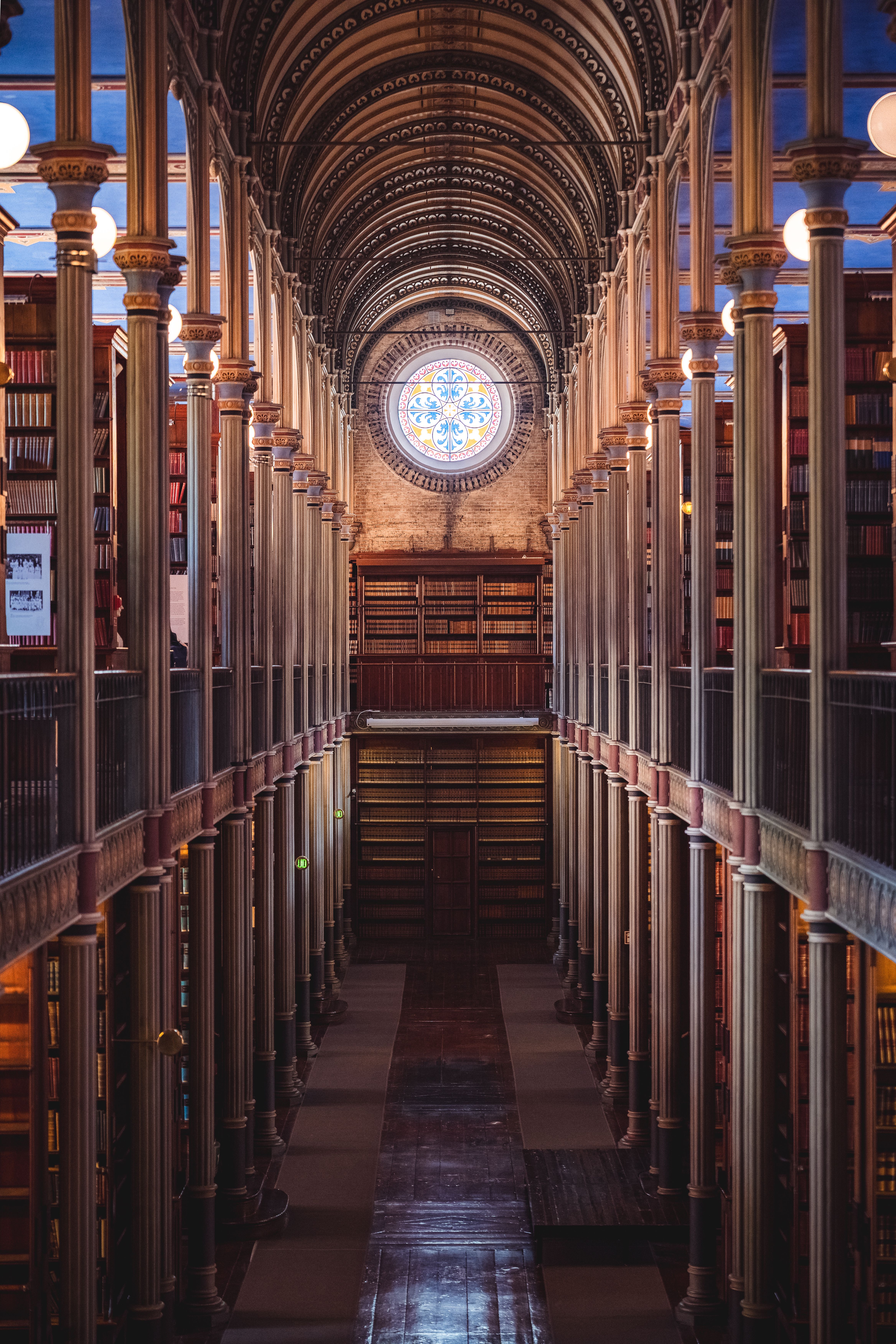 Explore the grandeur of a historic library's architecture, featuring a stunning stained glass window.