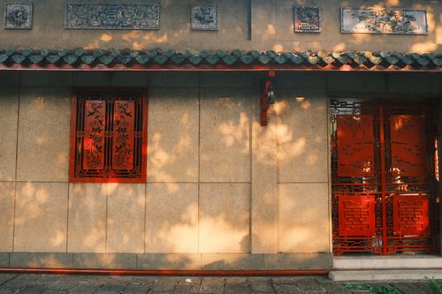 Free Sunlit traditional Asian temple wall with intricate red carvings in Ho Chi Minh City, Vietnam. Stock Photo