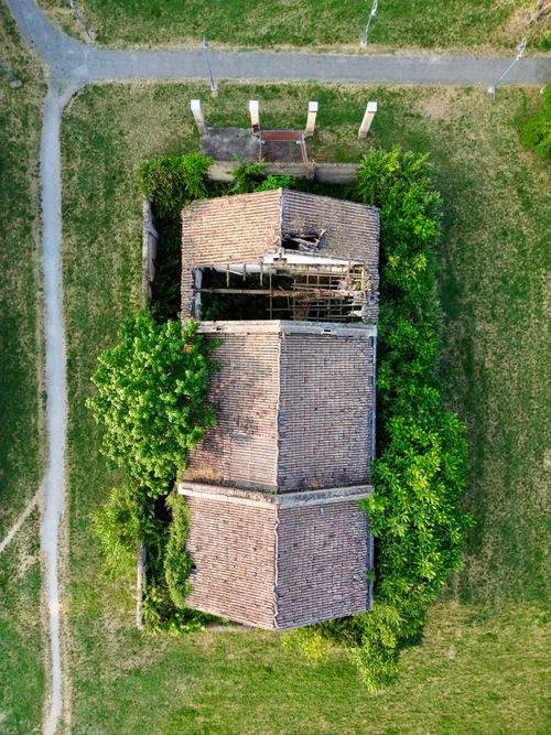 Free Top-down aerial shot of an abandoned building surrounded by green foliage, in Reggio Emilia, Italy. Stock Photo