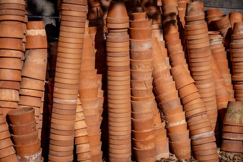 Free Abundant terracotta pots stacked vertically outdoors, showcasing natural earthy tones in sunlight. Stock Photo