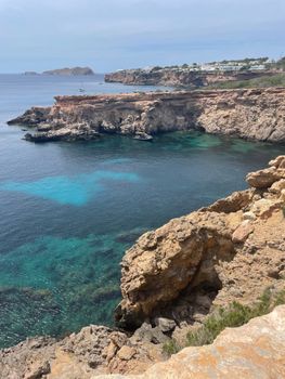Breathtaking view of Ibiza's rocky cliffs with beautiful azure waters below.