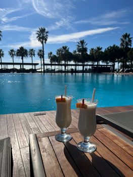 Two refreshing cocktails by a serene poolside in Antalya, Turkey, perfect for a summer getaway.