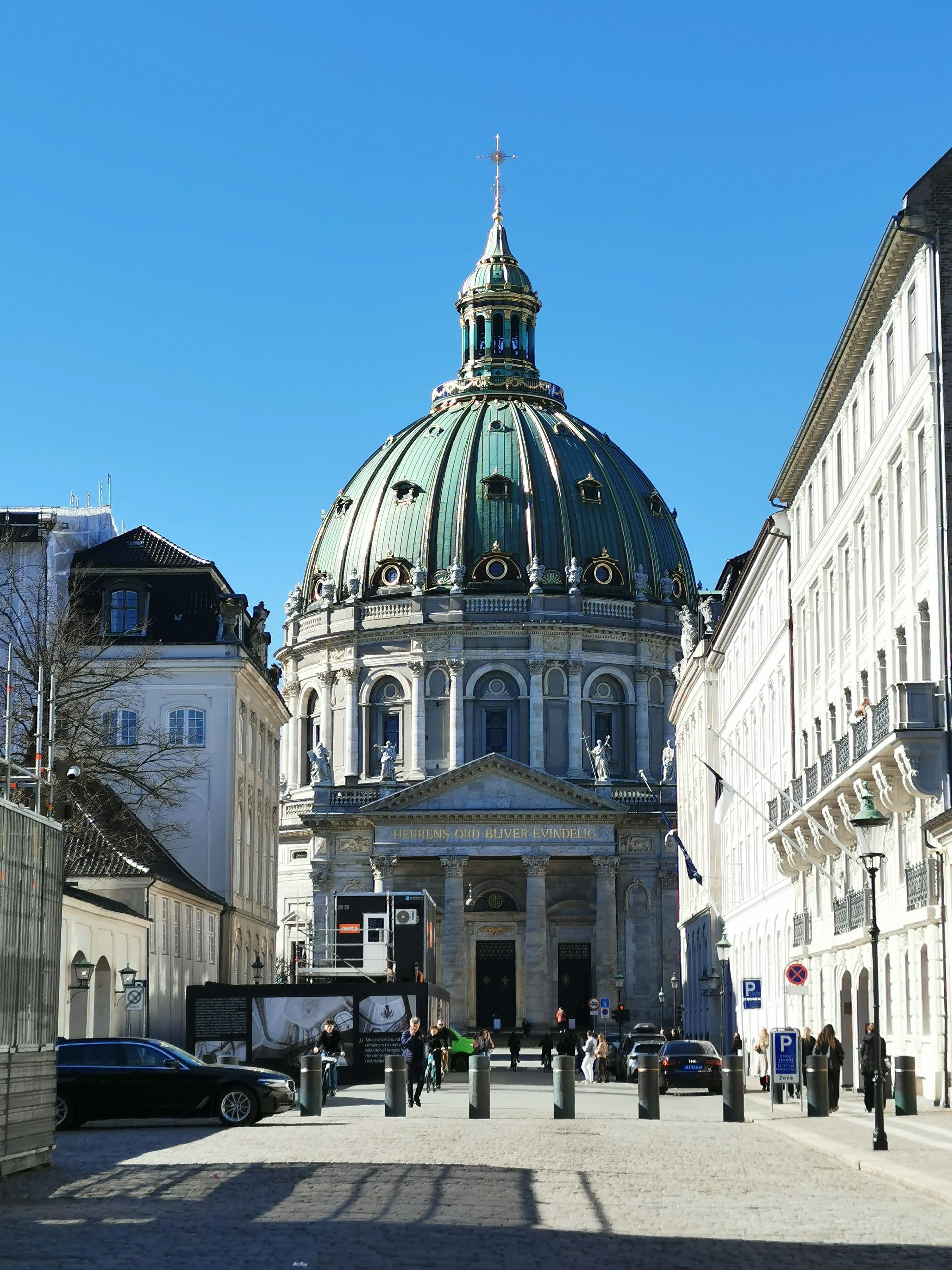 A sunny view of Frederik's Church in Copenhagen with vibrant architecture and clear blue sky.