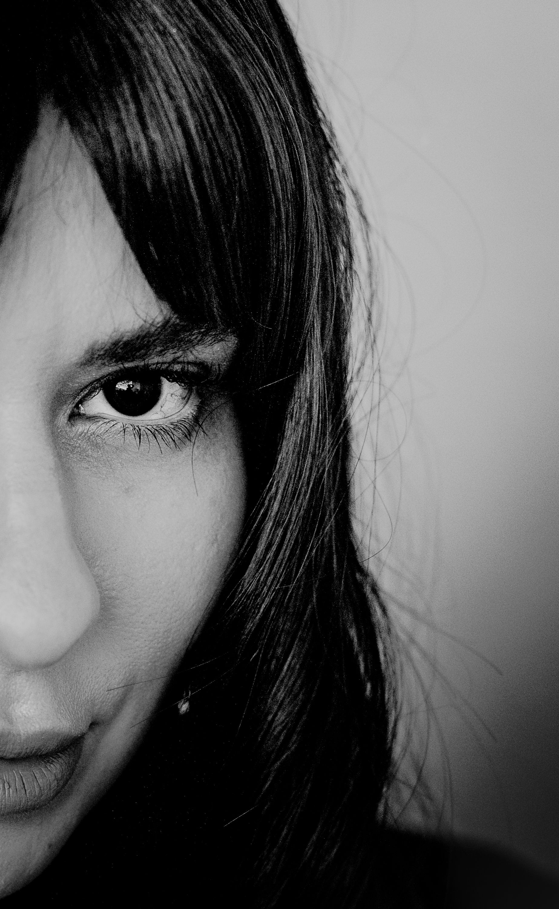 Fotomural Retrato artístico en blanco y negro en primer plano que captura la mitad del rostro de una mujer.