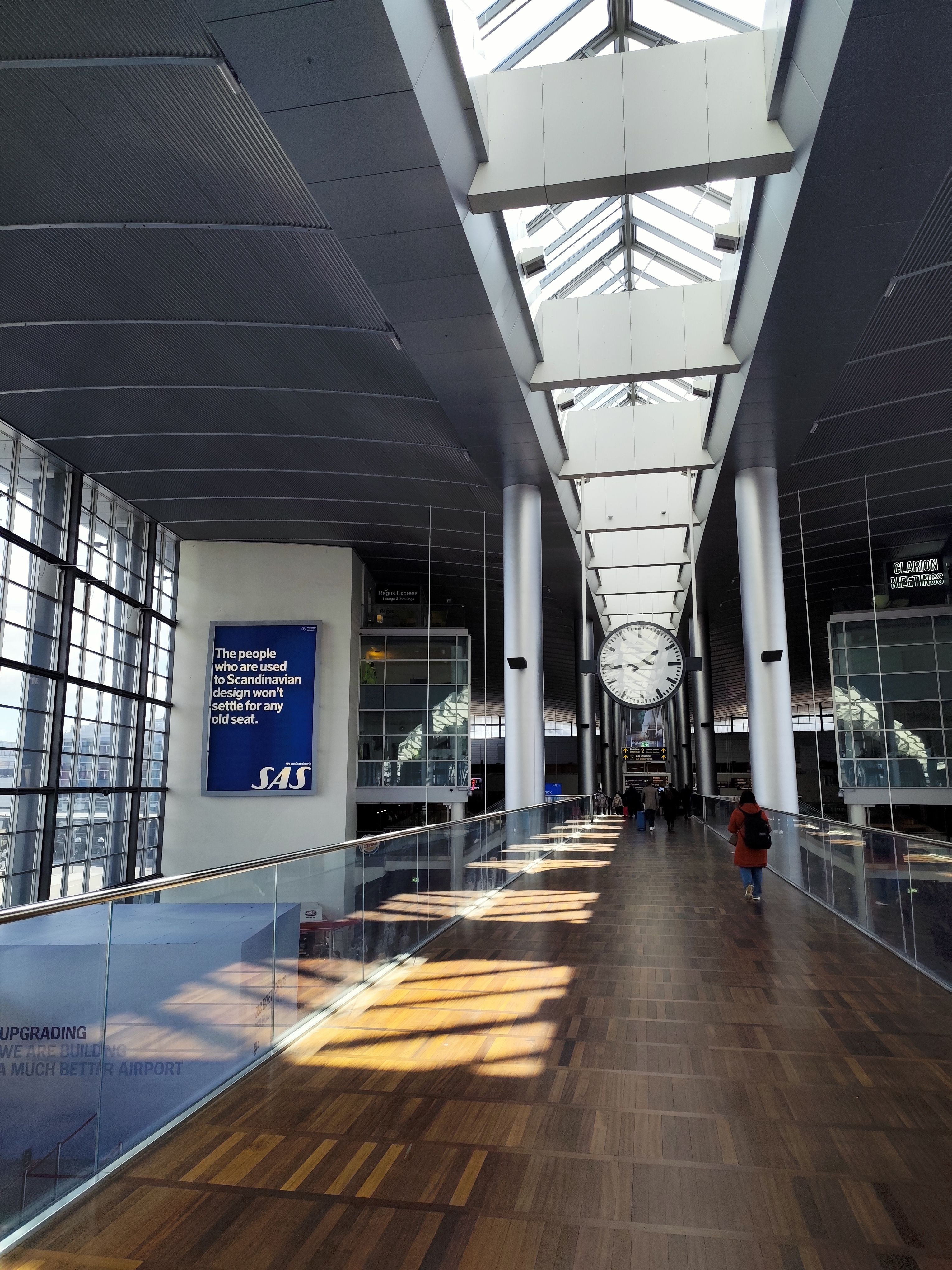 Capture of Kastrup Airport interior featuring a prominent clock and modern architecture.