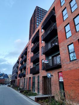 Red brick apartment building with multiple balconies in Copenhagen, Denmark.