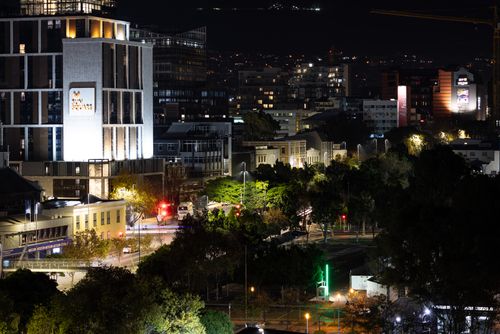 Free Dramatic nighttime view of a cityscape with illuminated buildings and streets, highlighting urban life and architecture. Stock Photo