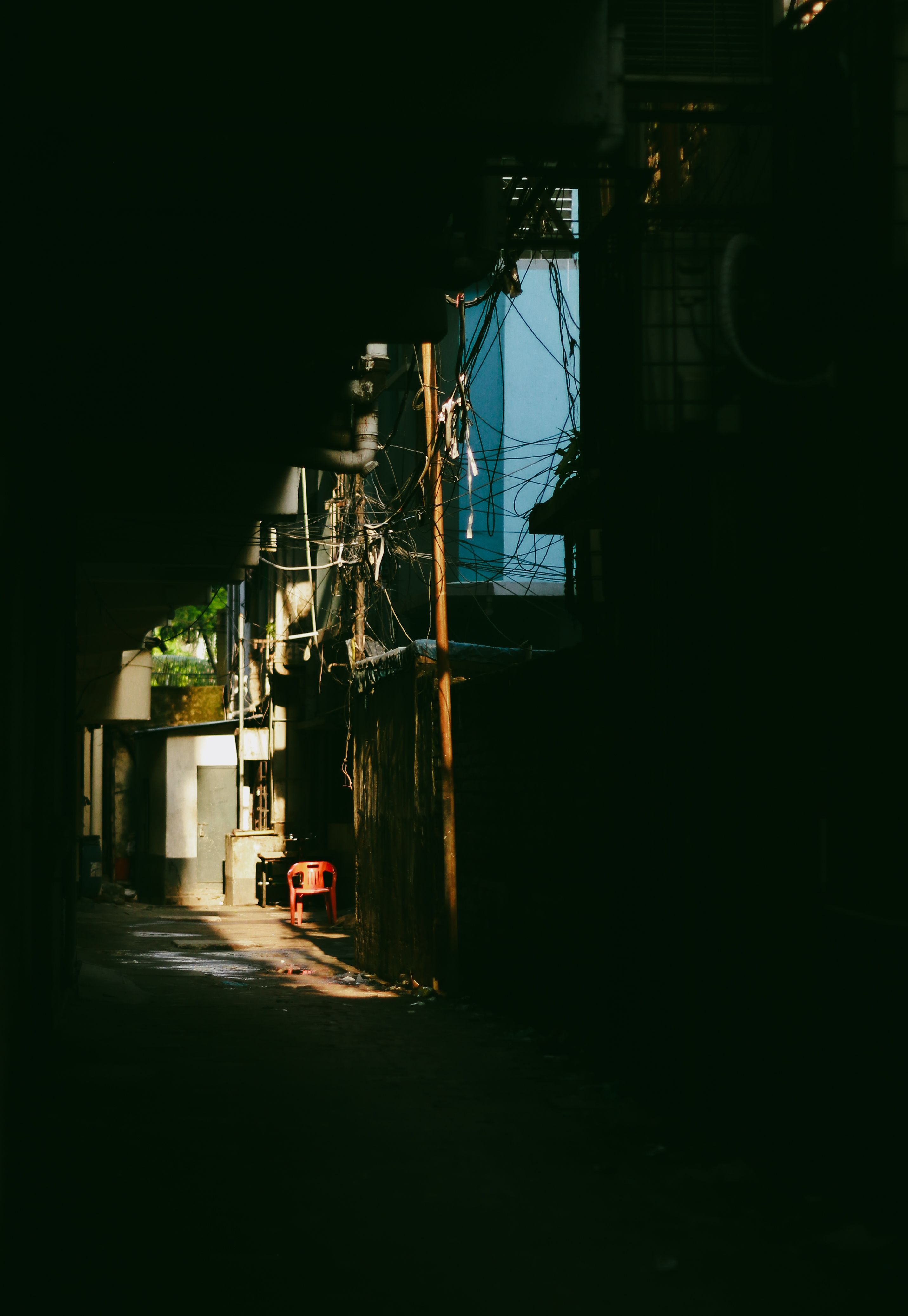 An atmospheric image of a narrow alleyway in Dhaka with soft sunlight piercing through.