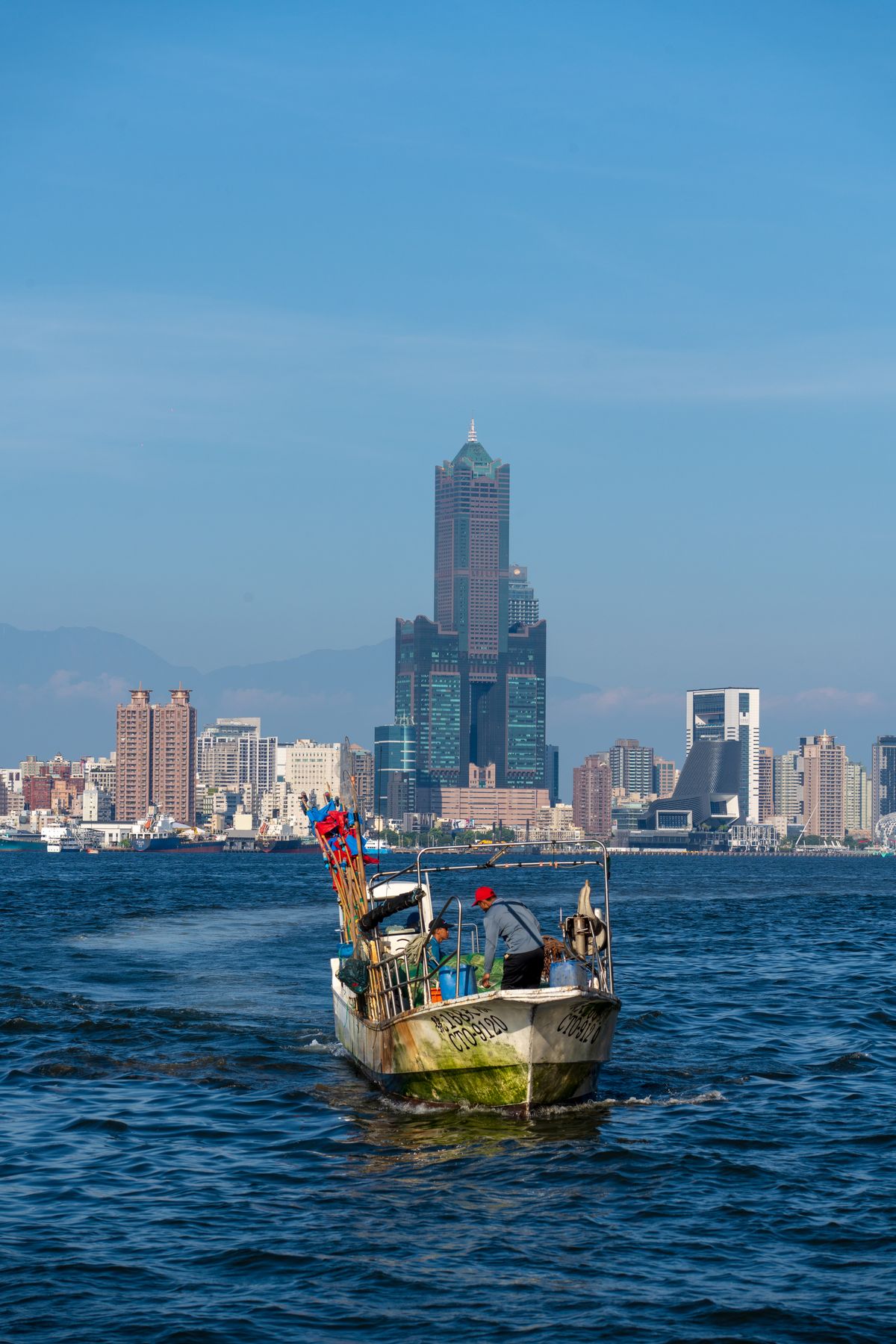 Fishing boat in Kaohsiung Harbor with the 85 Sky Tower skyline