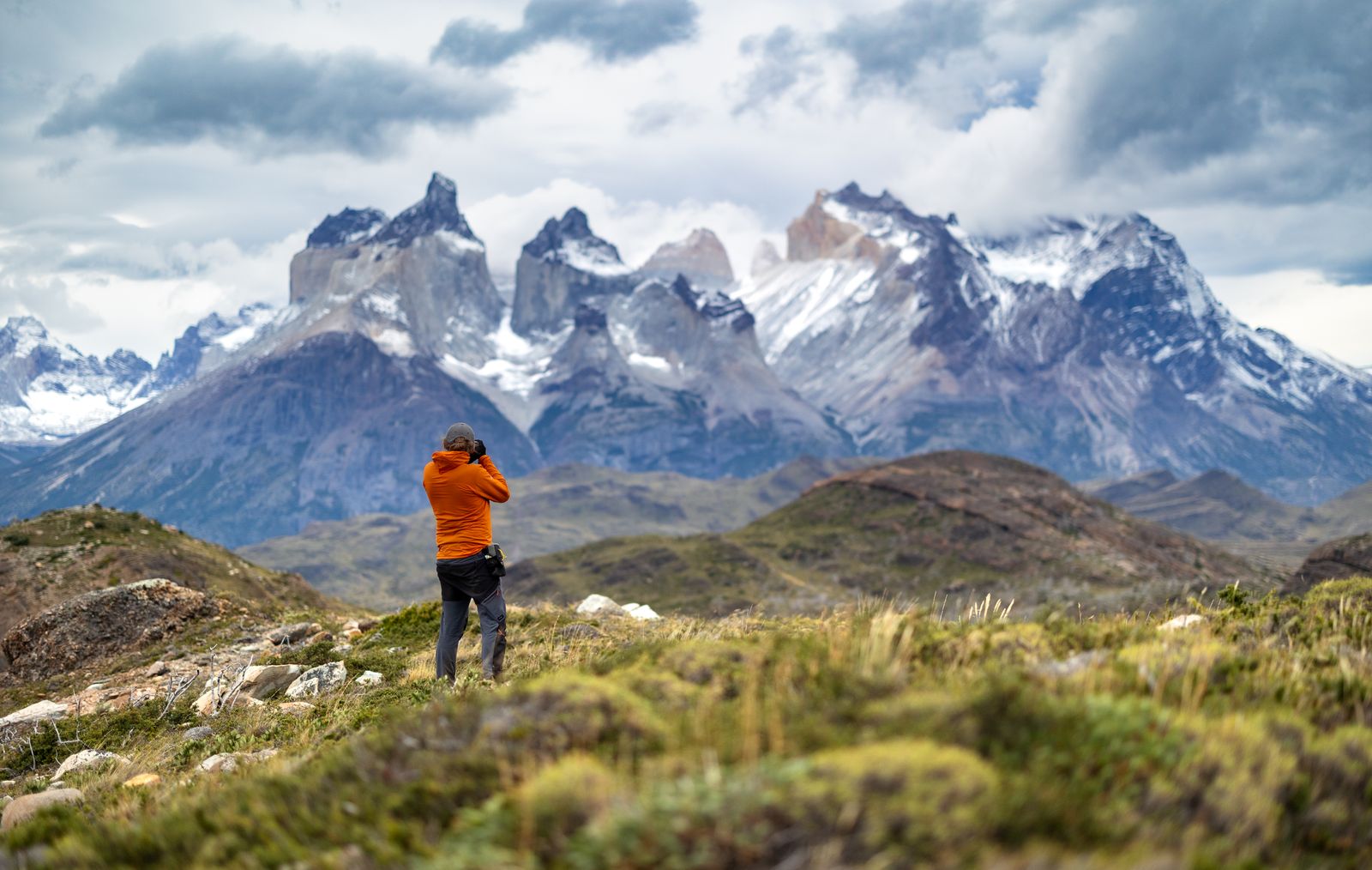 Trekker in an orange jacket below the granite spires of southern Patagonia — photo by Marek Piwnicki on Pexels