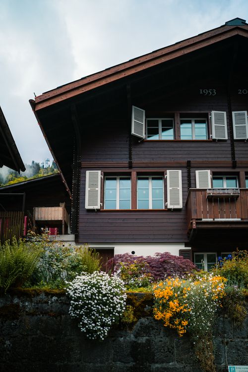 Free A quaint Swiss chalet surrounded by vibrant flowers in Lauterbrunnen, capturing Alpine charm. Stock Photo