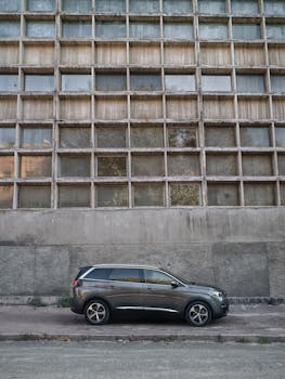Grey SUV parked in a city street against a concrete building facade in Kyiv, Ukraine.
