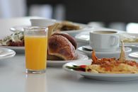 A vibrant Mexican breakfast spread featuring orange juice, coffee, pastries, and traditional dishes.