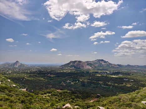 A breathtaking aerial view of a vast, green landscape under a vibrant blue sky.