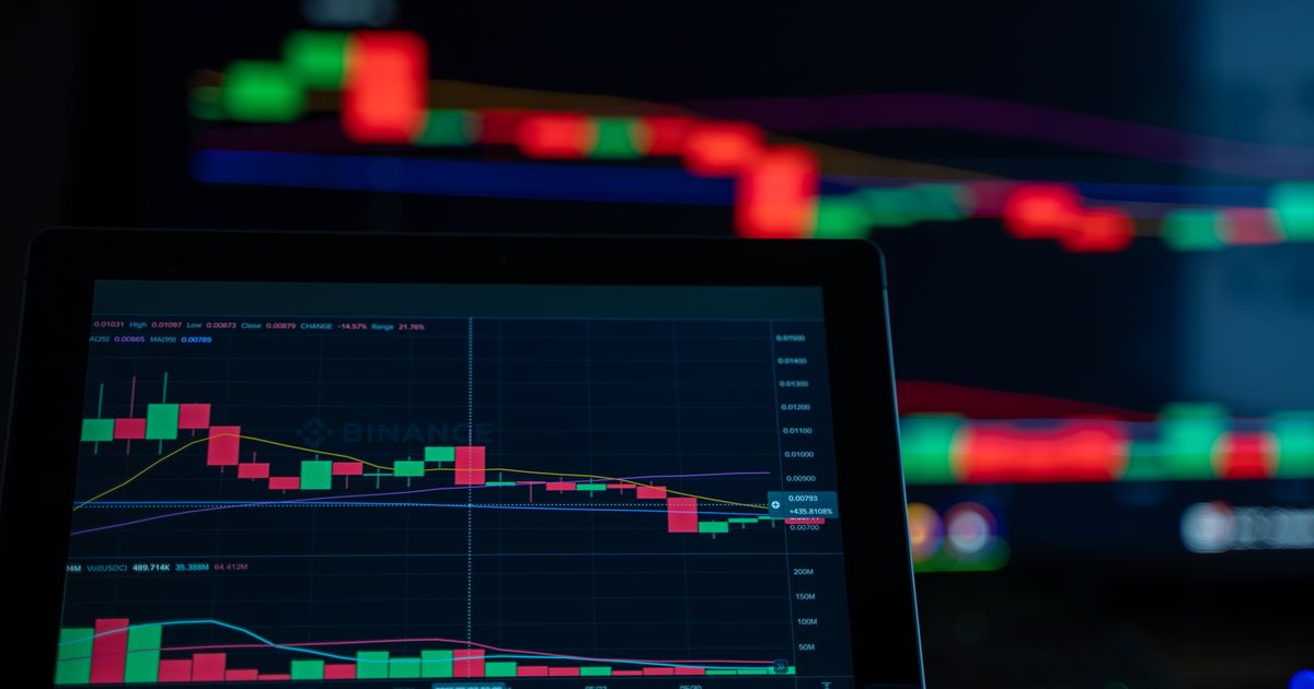Trader's tablet showing a red and green candlestick chart used to illustrate margin trading risk