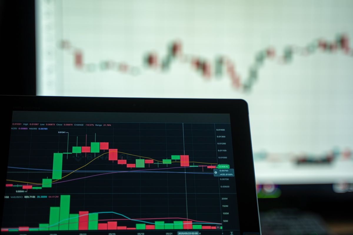 Financial charts on a laptop in a dark workspace