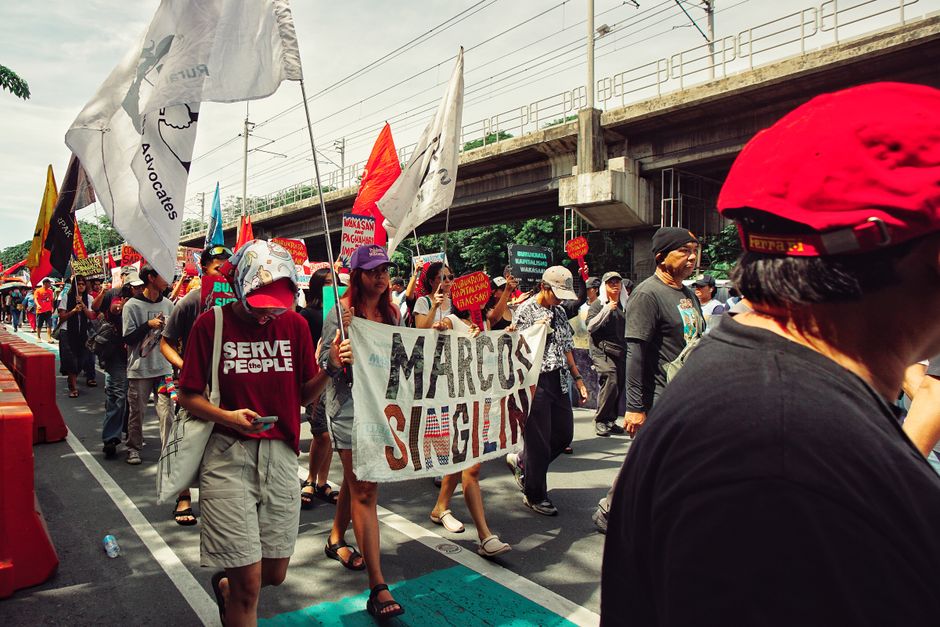 Un grupo de personas en una manifestación política con pancartas y banderas que muestran activismo social y político.