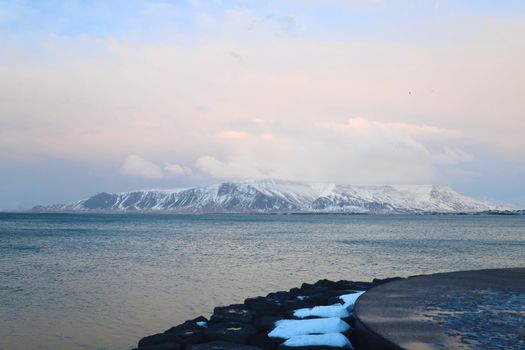 Breathtaking winter landscape of Esja Mountain with snow-covered peaks near Reykjavík, Iceland.