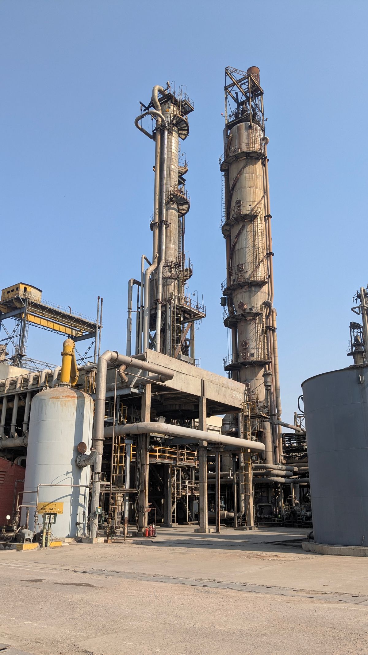 Oil and gas refinery towers and structural equipment under blue sky