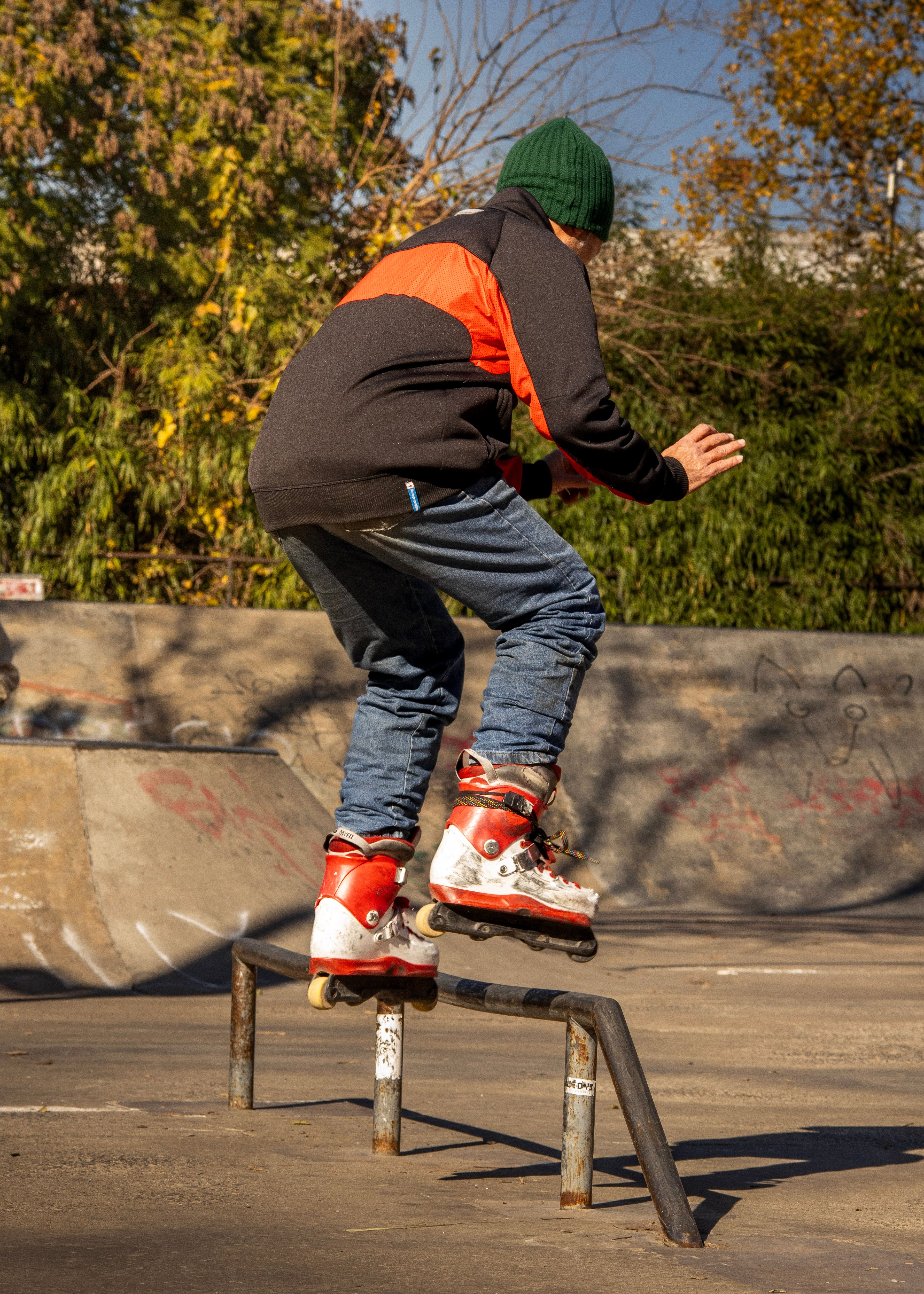 Young skater in action grinding a rail at a vibrant outdoor skatepark.