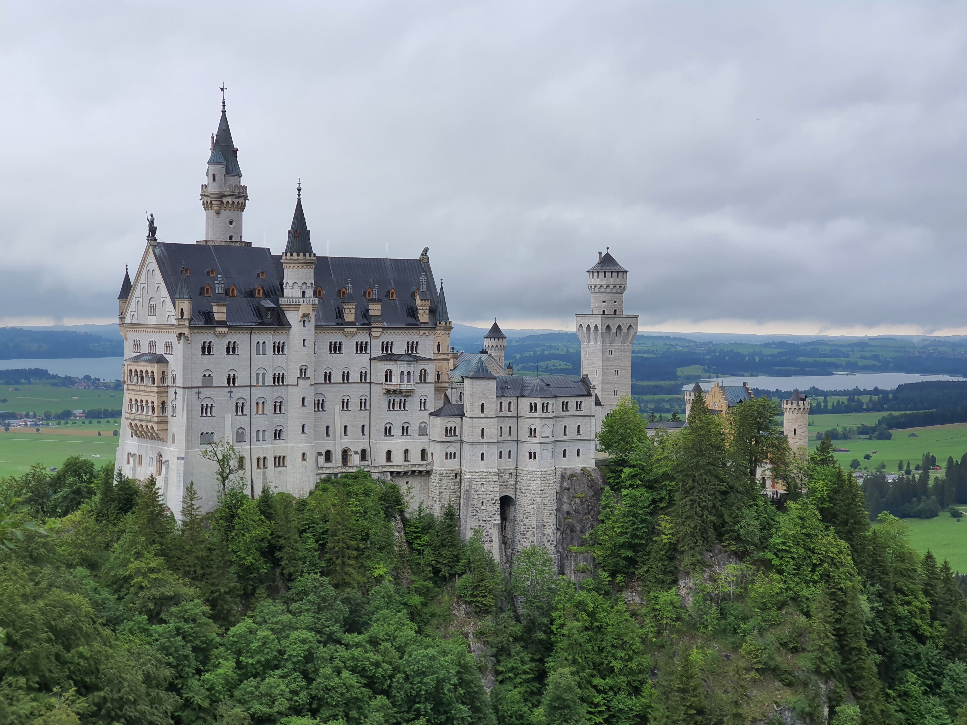 Stunning view of the iconic Neuschwanstein Castle surrounded by lush green forests in Bavaria, Germany.