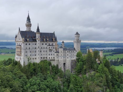 Stunning view of the iconic Neuschwanstein Castle surrounded by lush green forests in Bavaria, Germany.
