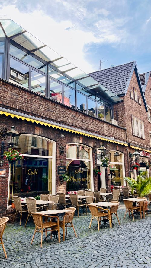 Free Cozy outdoor café setting under blue skies in Akwizgran, Germany. Perfect for relaxation. Stock Photo