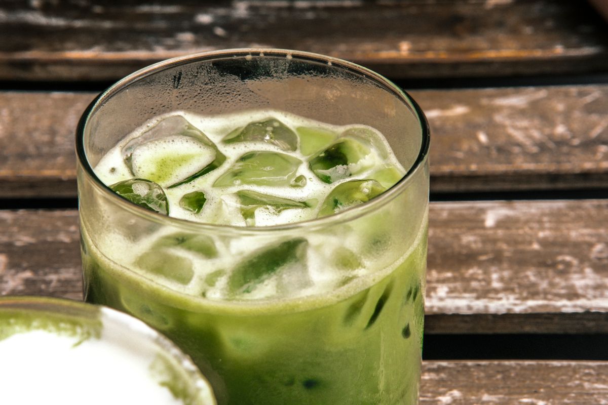 An iced matcha latte on a wooden table.
