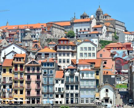 Vibrant facades of historic Porto buildings with orange rooftops under a clear sky.