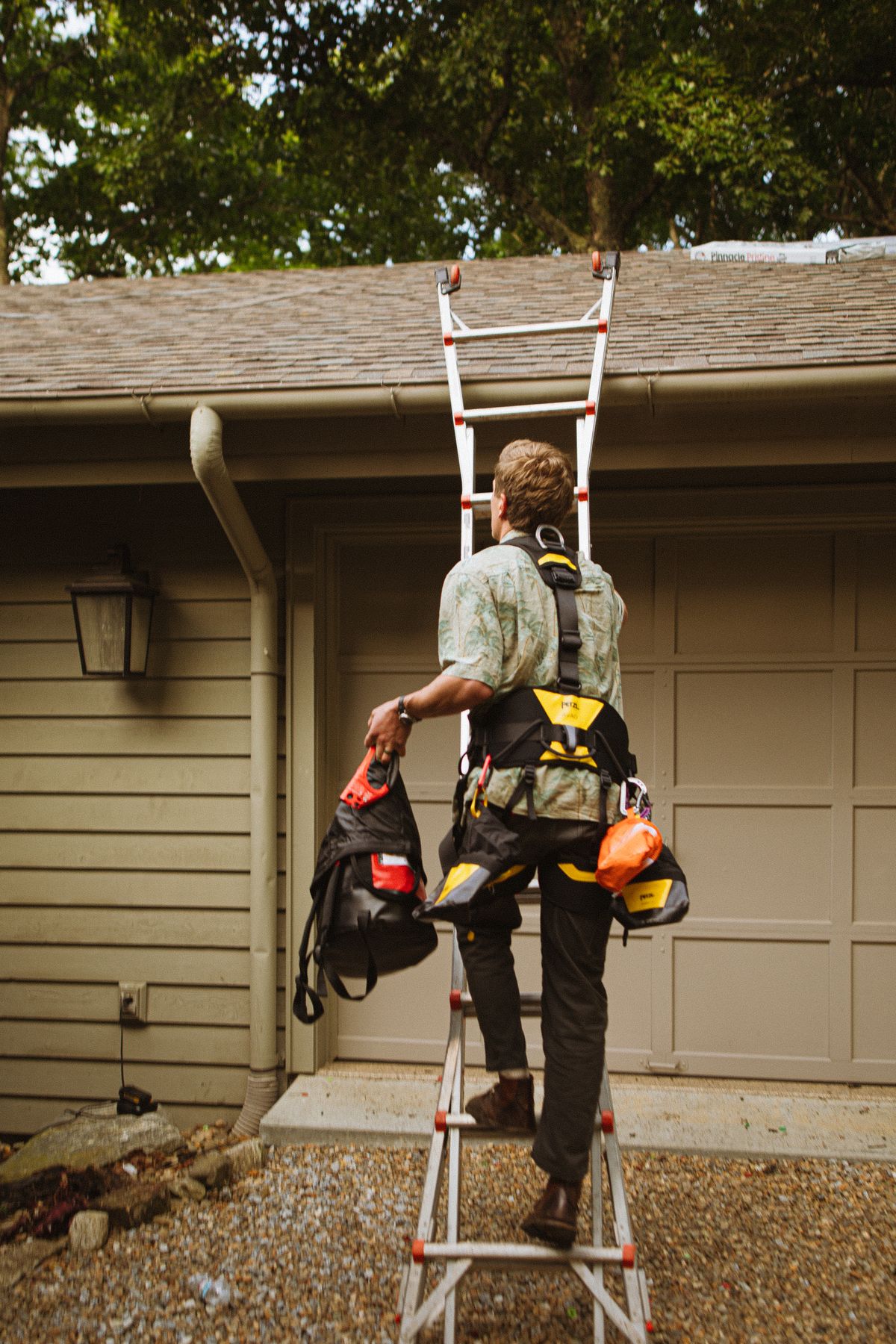 Roofing services in Clovis – roofer with safety gear ascending a ladder