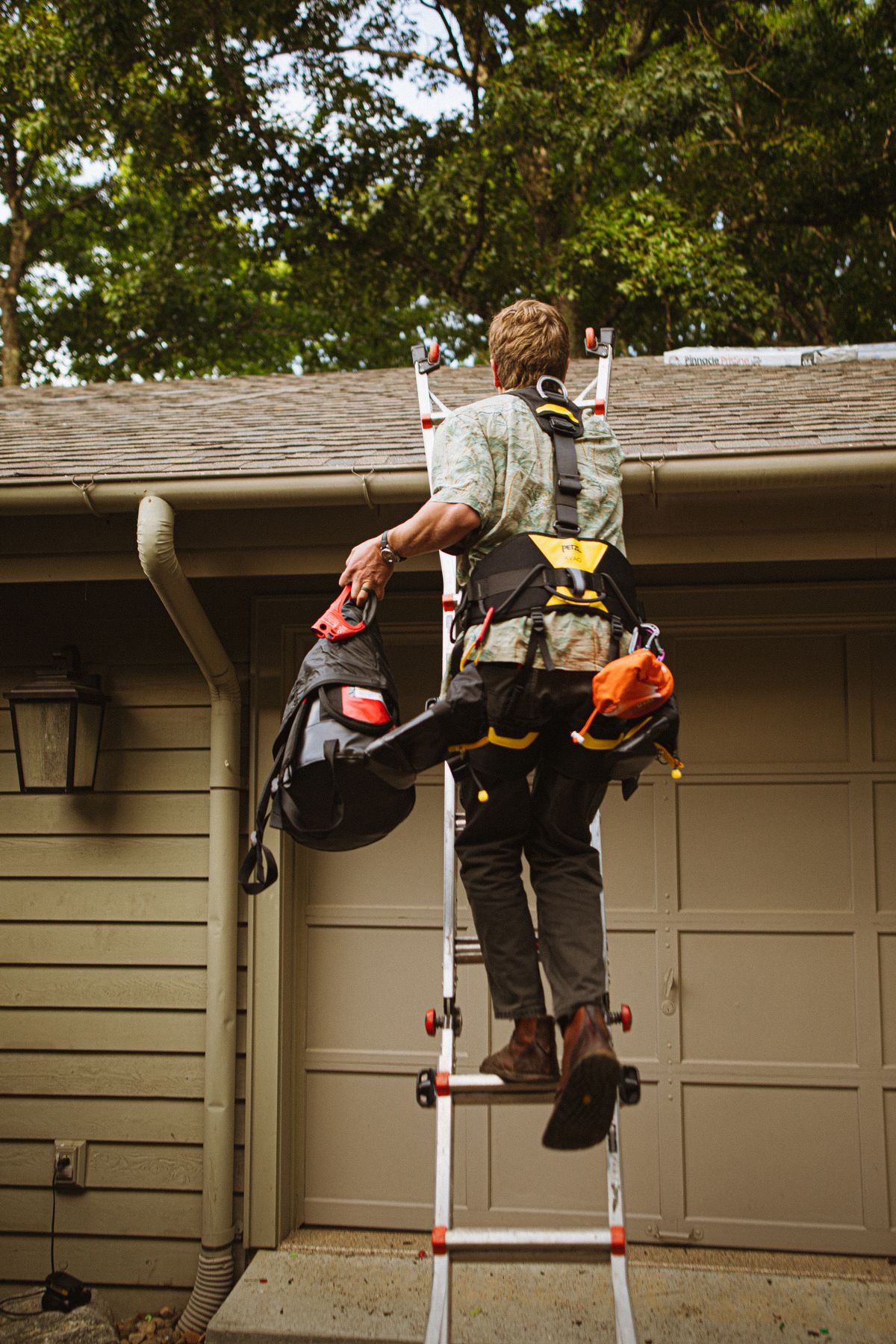 Roofing services in Tulare – skilled roofer climbing a ladder for roof work
